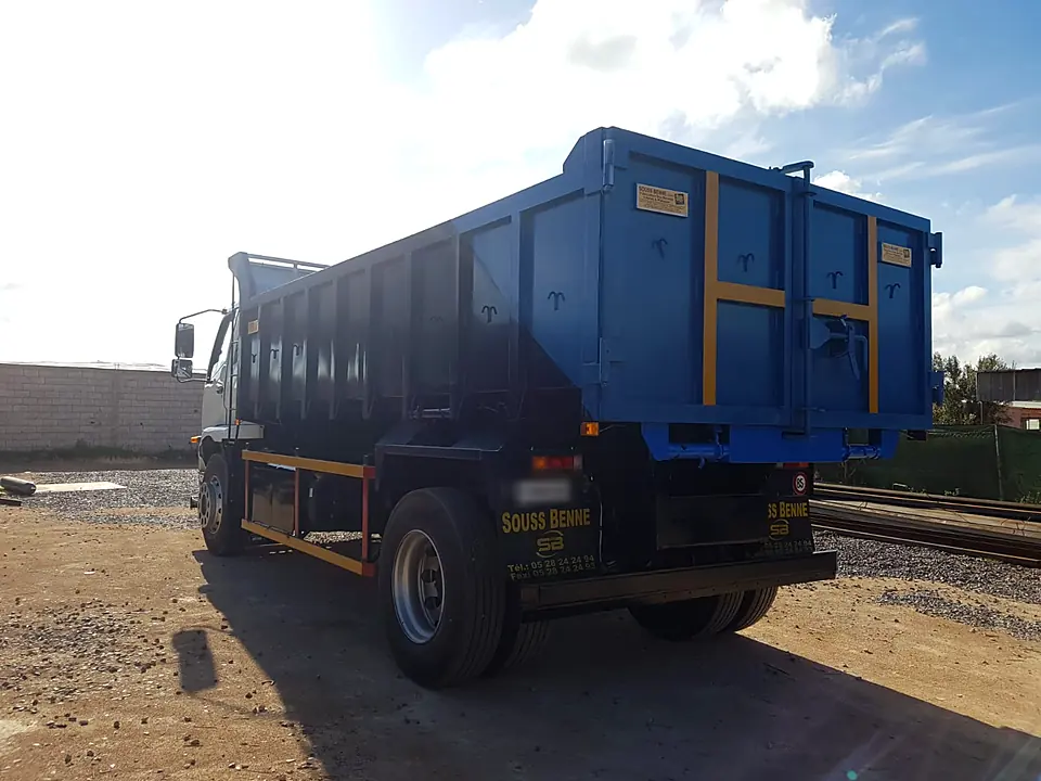 Benne bleue à renforts jaunes montée sur camion porteur, réalisation Souss Benne dans le Souss
